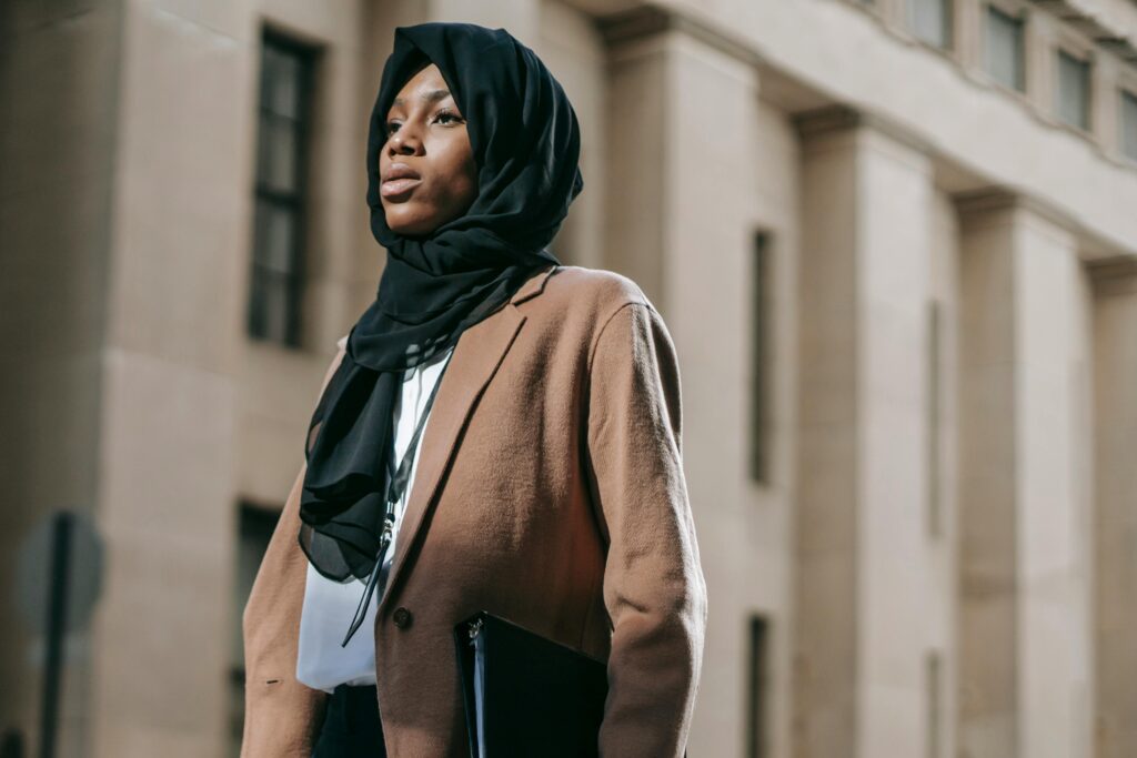 Wanita menggunakan hijab hitam yang dikombinasikan dengan outer berwarna golden brown